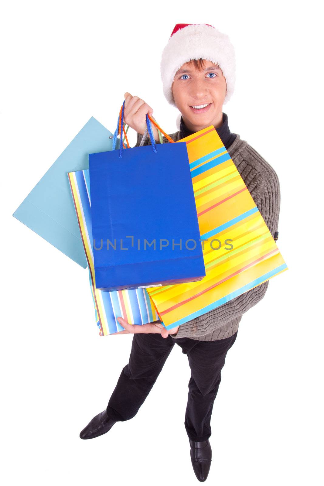 young man in a Santa Claus hat handing gift bags