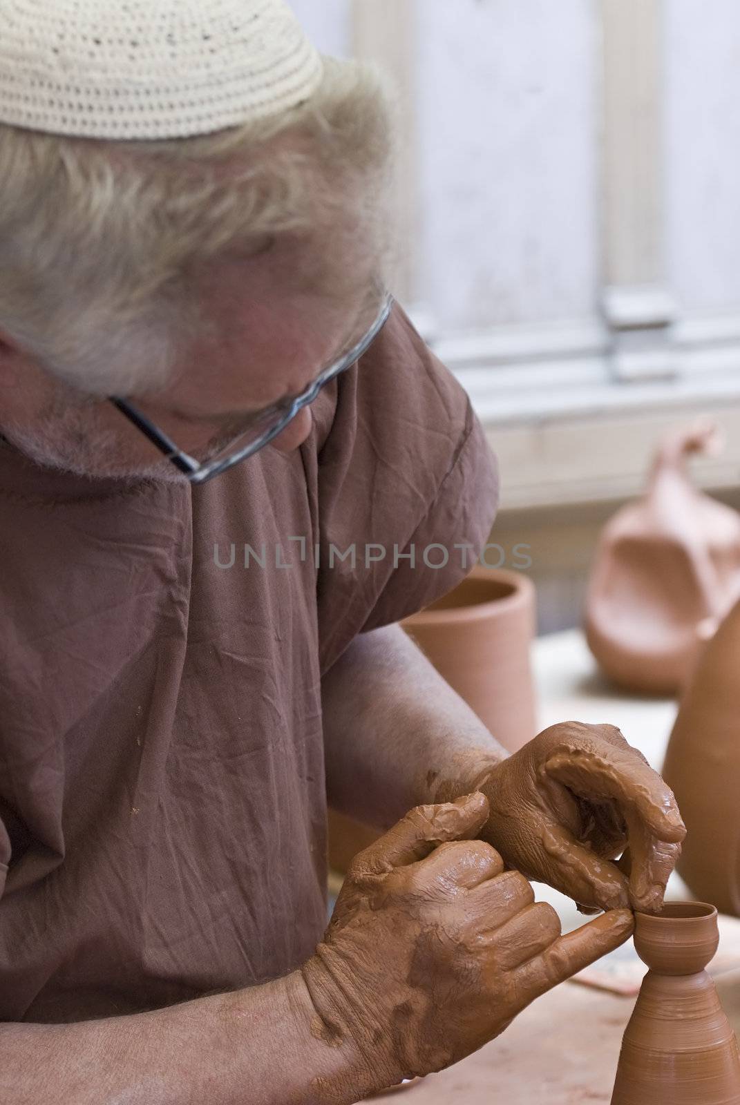 Potter working with his hands. by angelsimon