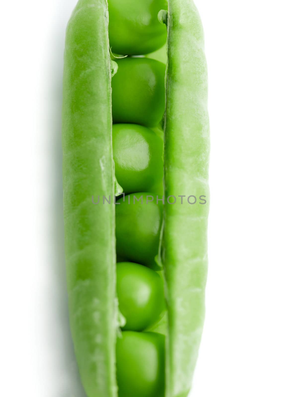 A pea pod revealing peas against white background