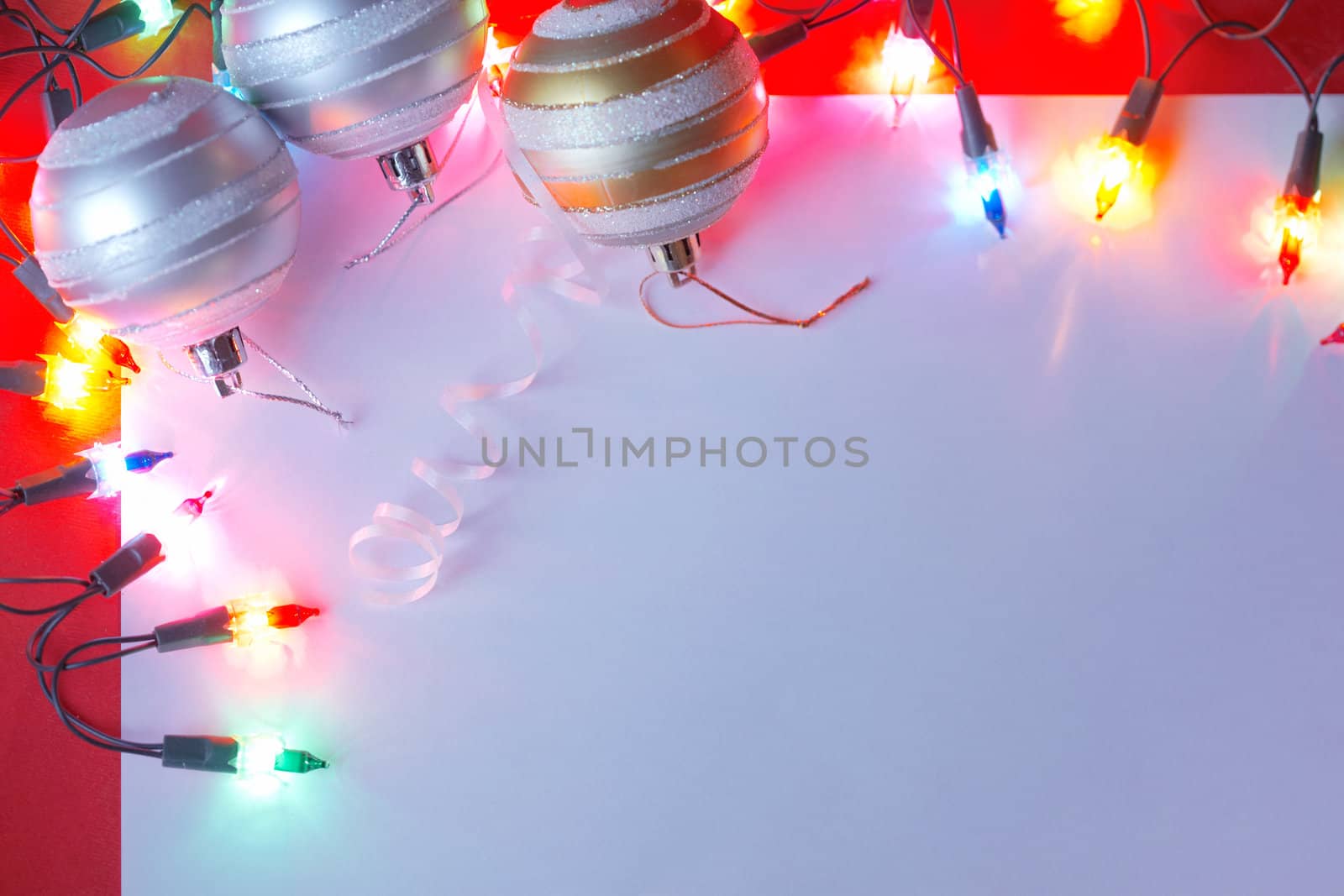 New Christmas baubles border with holiday lights. by romanshyshak