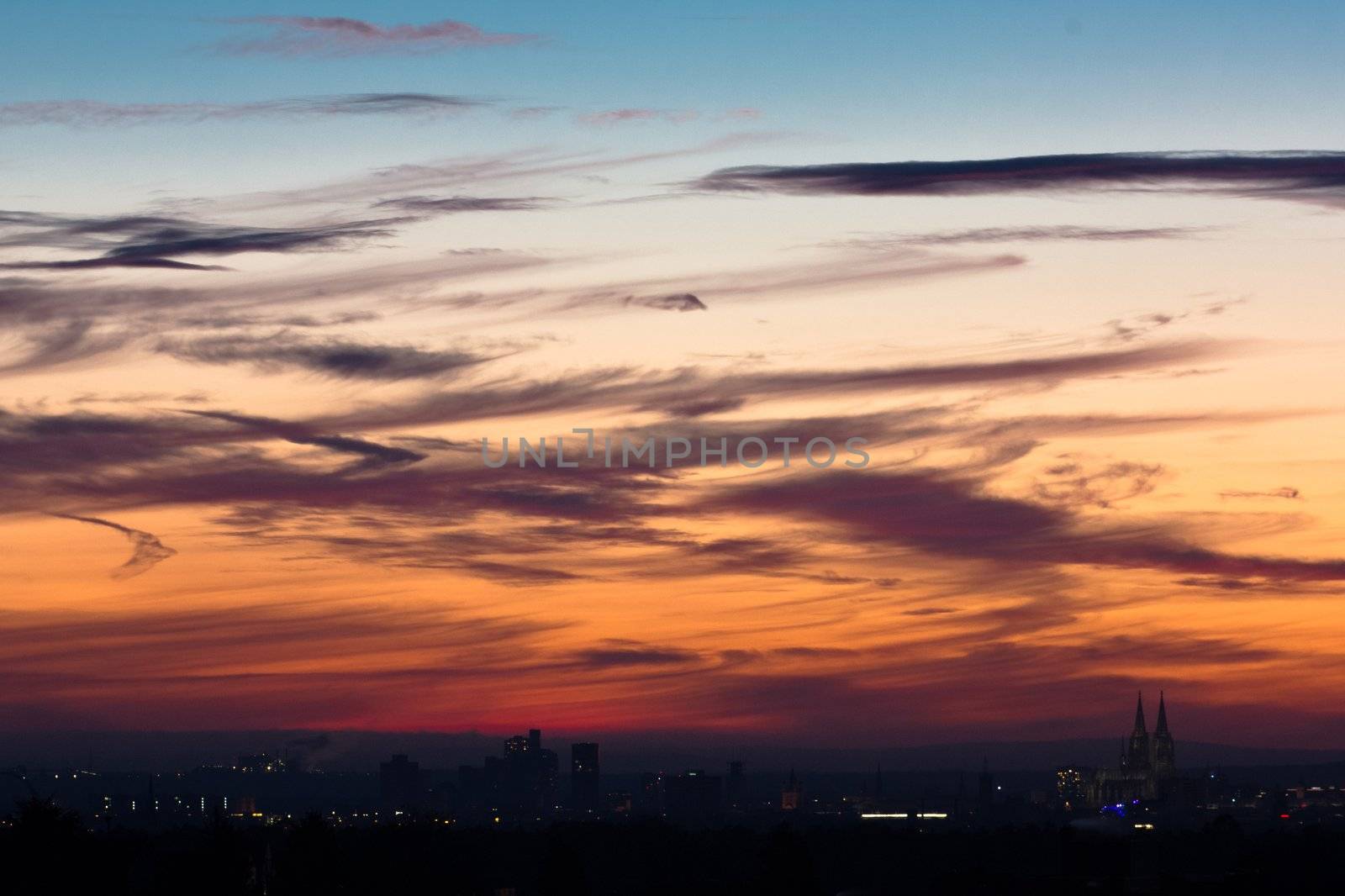 Skyline of Cologne at early evening, impressing colors in the clouds and sky