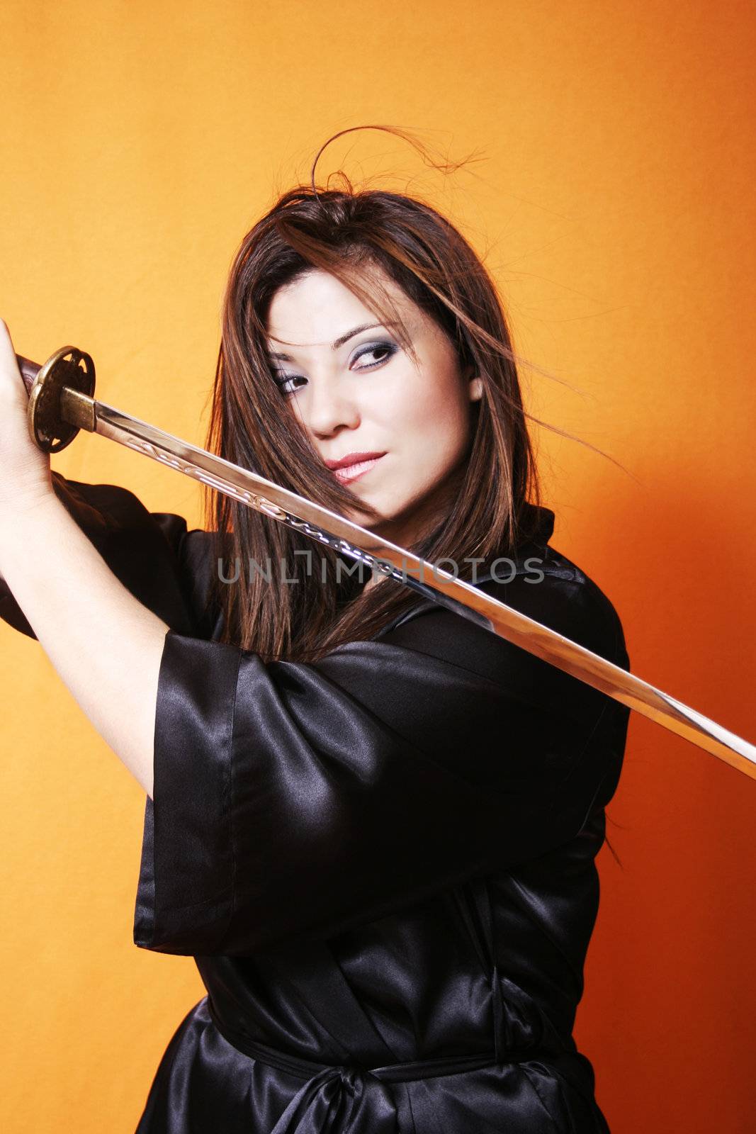 Woman swings a sword, hair swooshes, eyes intent. 