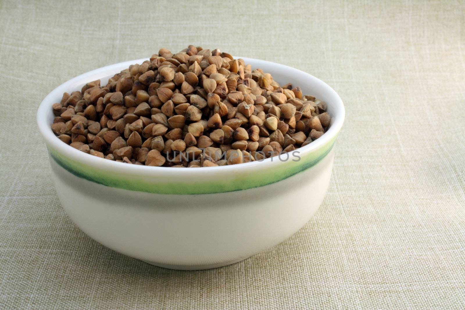 Some buckwheat in small bowl on linen background