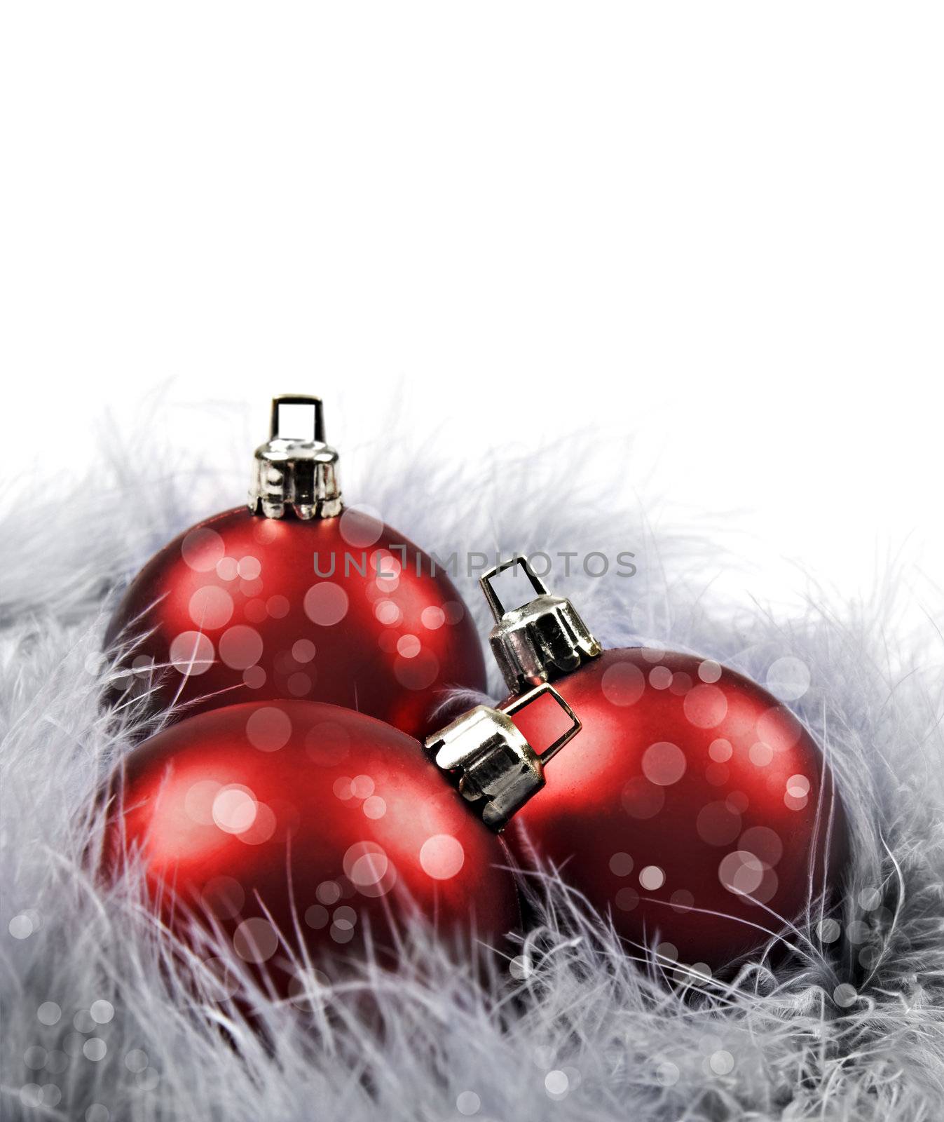 Red christmas baubles on a white background with space for text by tish1