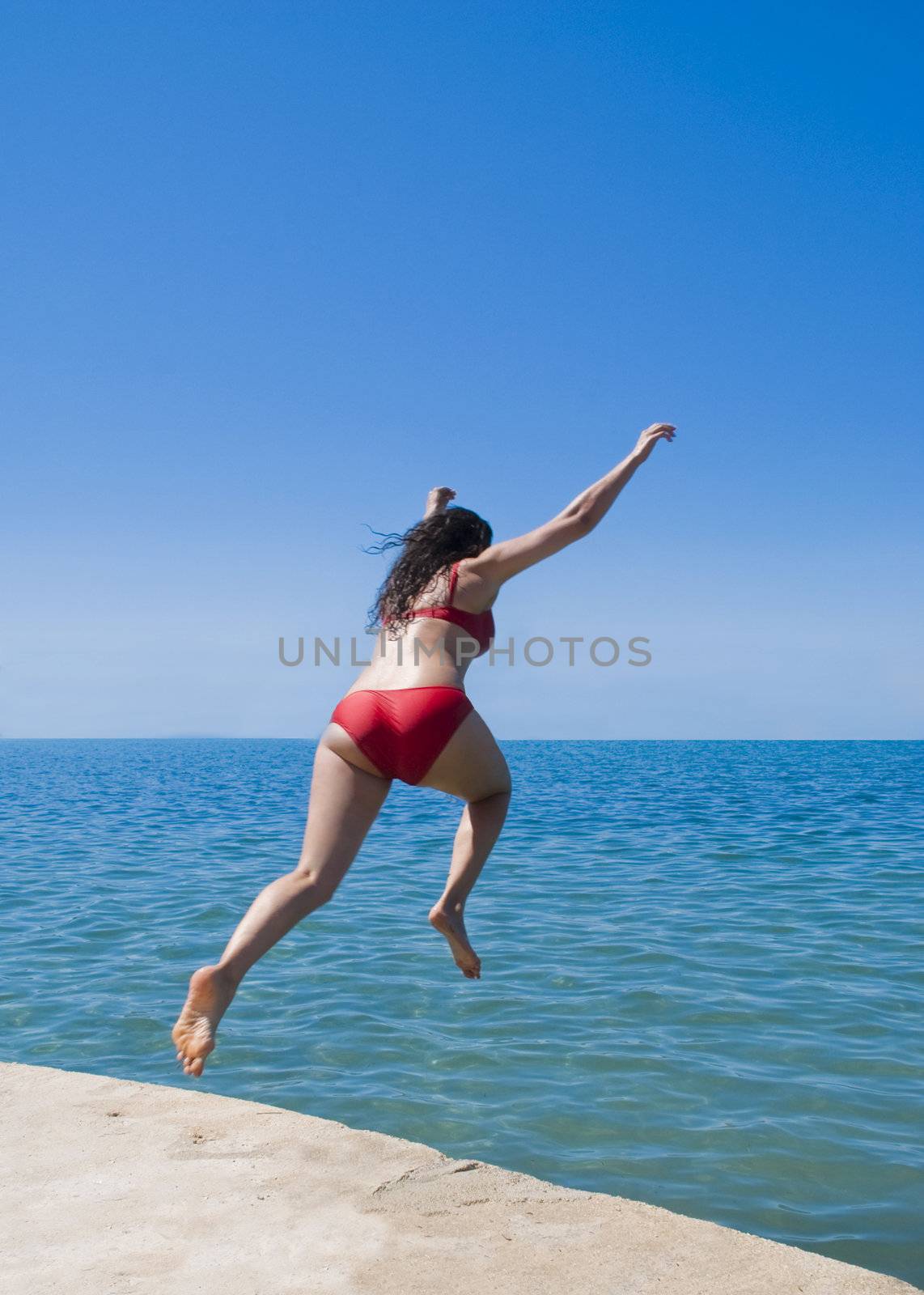 A woman photographed leaping into the sea.