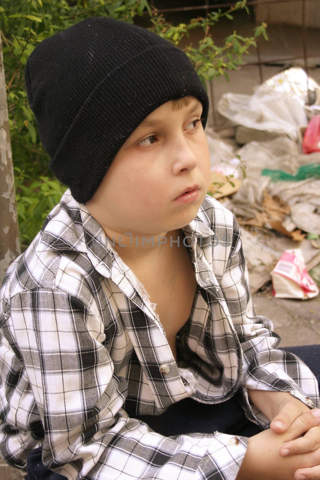 From a hopeless future
Boy wears mismatched clothing and sits in an urban grotto.
(focus soft)