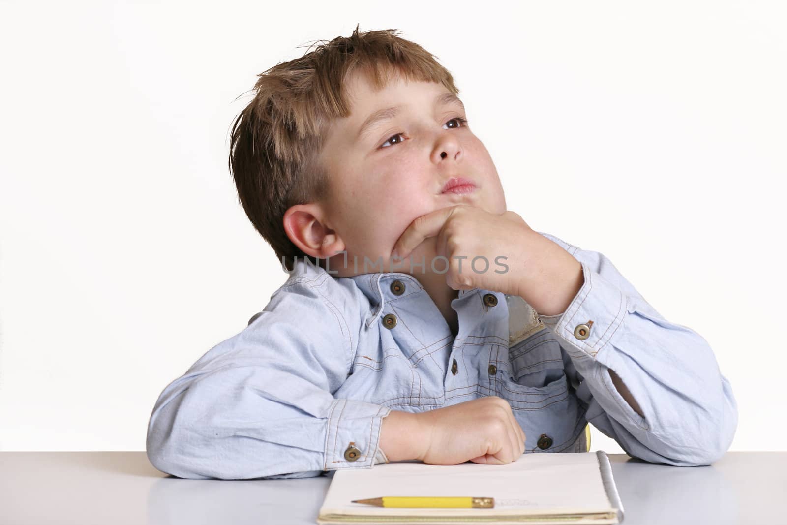 Boy child thinking about what to write 