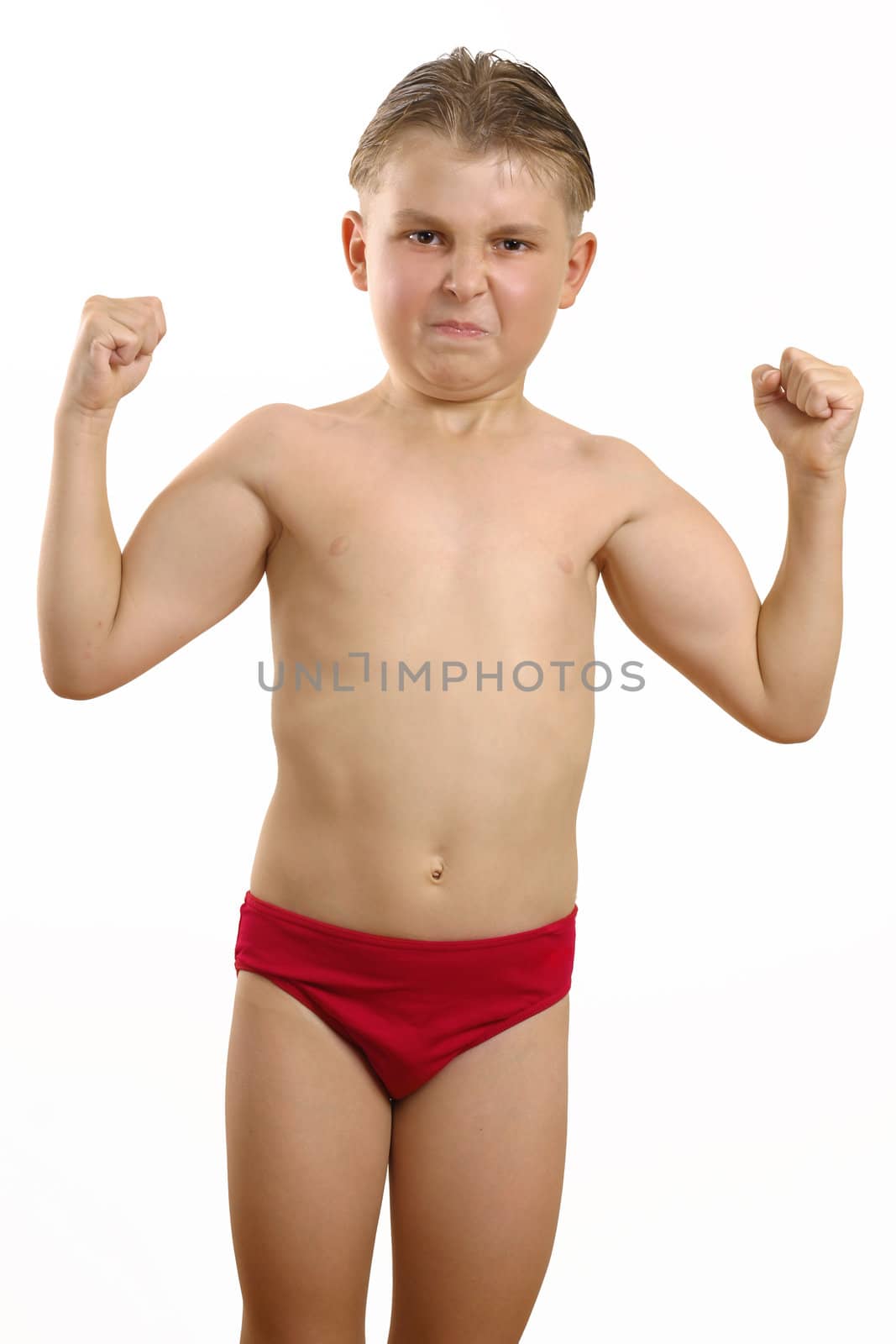 Skinny boy in swimmers flexes bicesps both arms