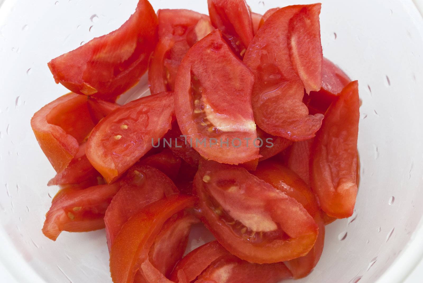 Slices of fresh tomato in white bowl