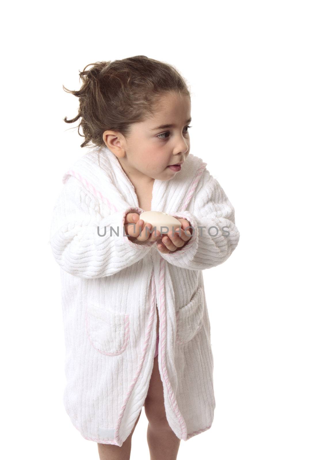 A young girl holding soap is looking sideways with some space for copy...