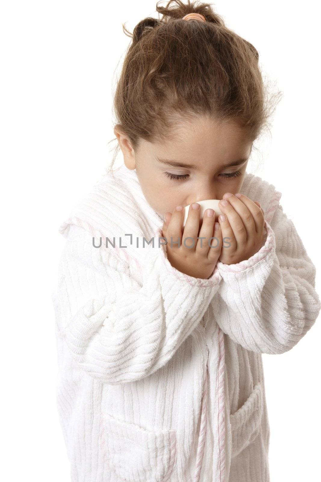 Young girl in bathrobe sniffing fragrant perfumed soap