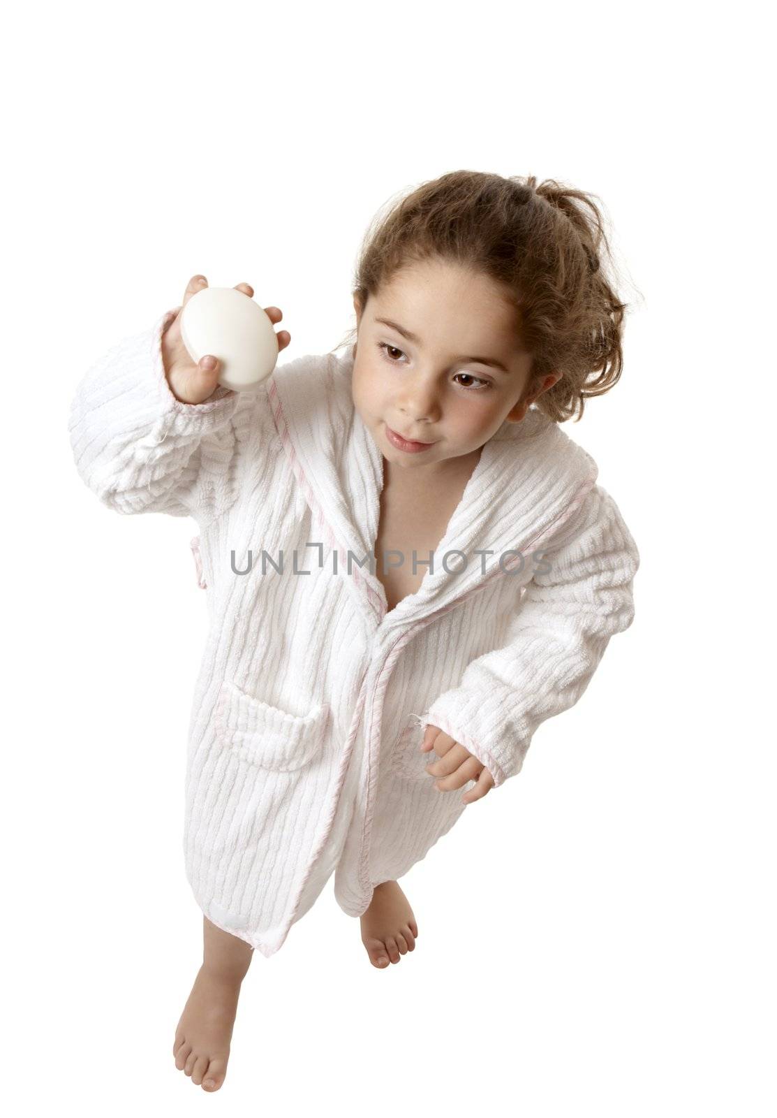 Young girl in bathrobe holding a bar of soap.