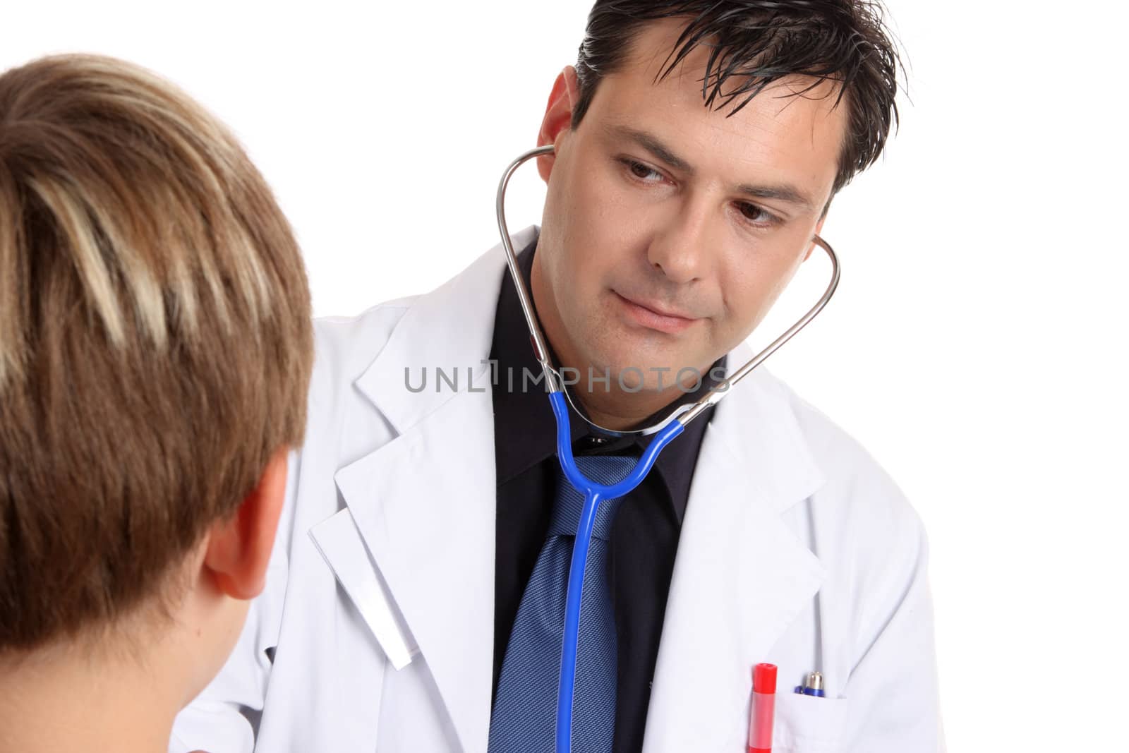 A sick young  patient is being examined by a medical practitioner who is  using a stethoscope.  With horizontal space for copy