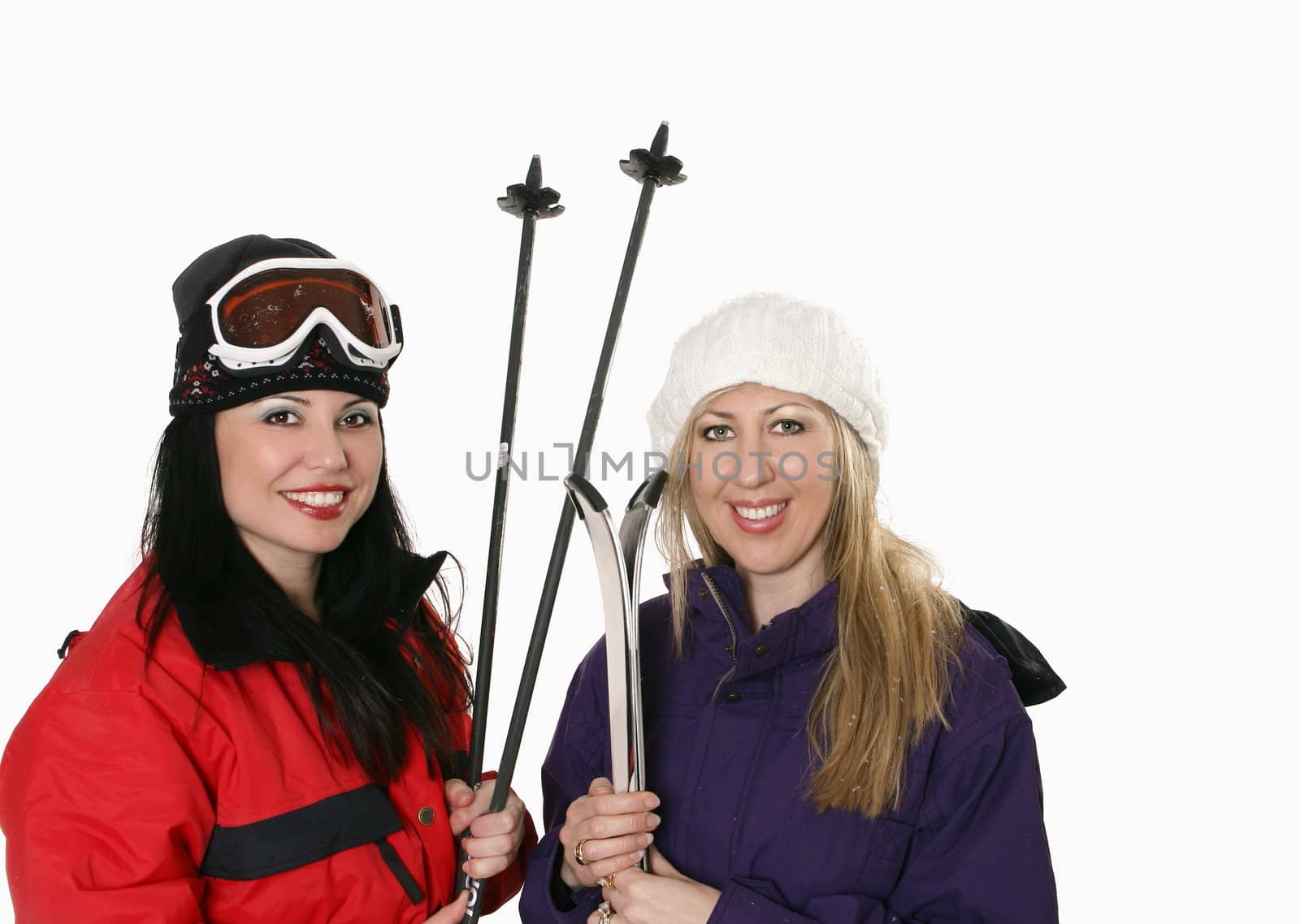 Two women dressed in warm parkas and holding skis