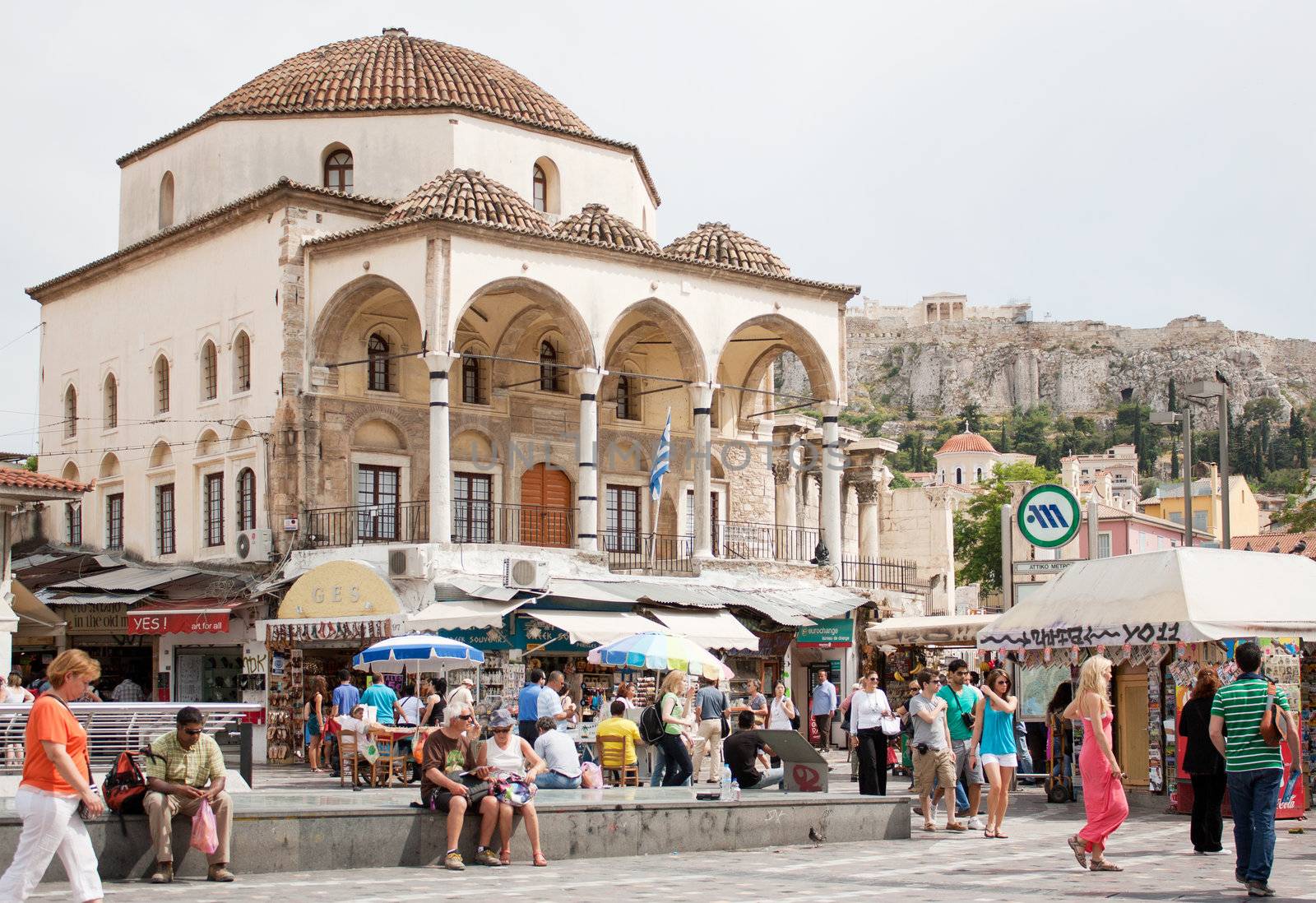 Greece on the verge of bankruptcy. Tourism is a sector of hope for Greek economy. Athenians and tourists in Monastiraki Square in Athens, Greece, 24 May, 2011. Market stalls, Tzistarakis Mosque and the Acropolis in the background.