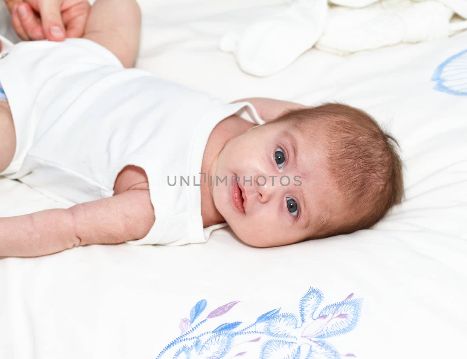 Smiling baby girl lying on bed