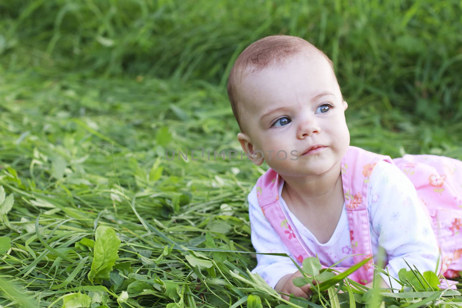 Sweet baby girl lying on grass