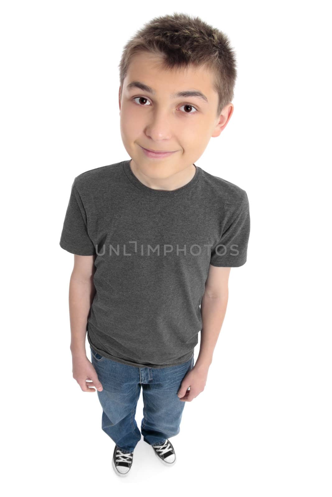 Above view of a pre teen boy.  He is standing and wearing blue jeans, sneakers and t-shirt