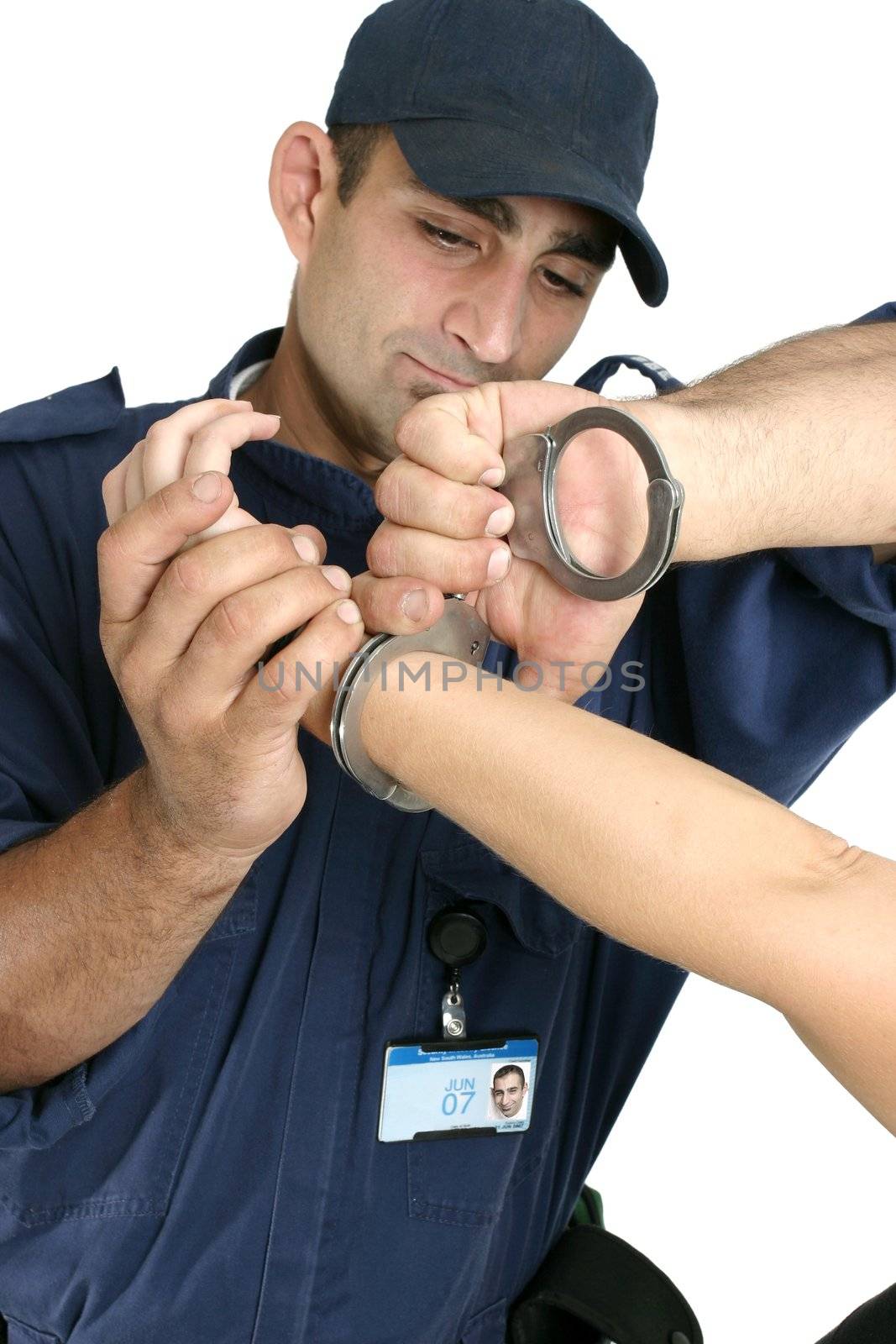 A criminal is apprehended and handcuffed.  Please note:  Photo on badge is same person and photographed by me.
