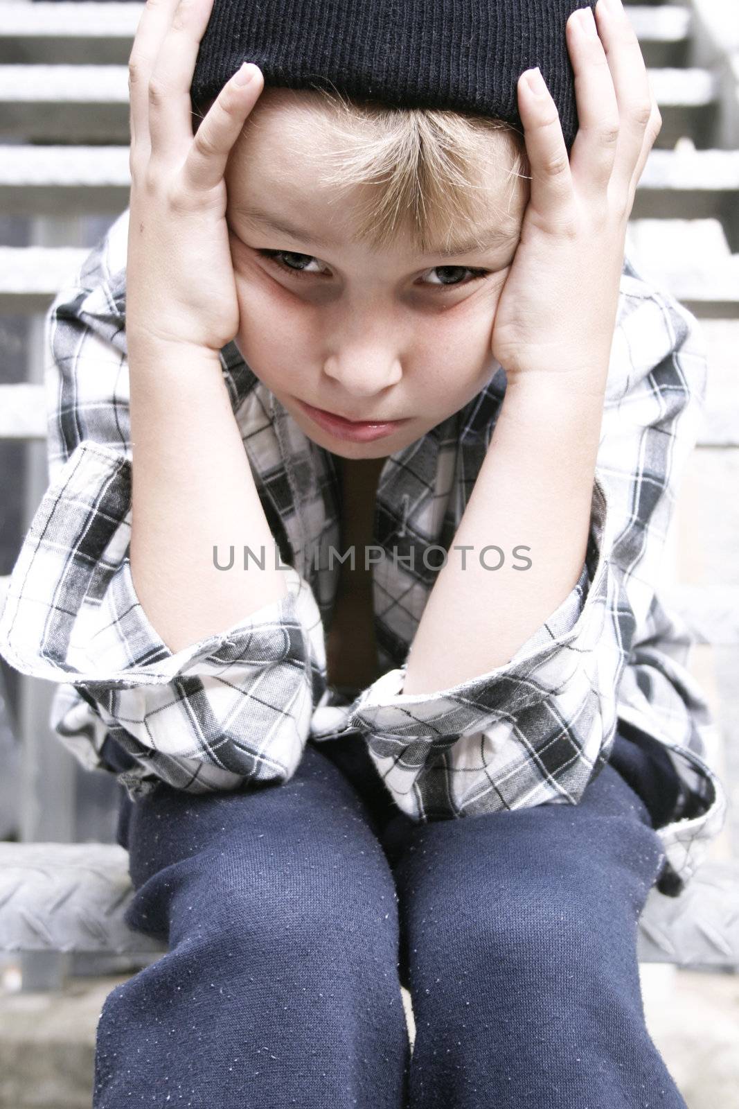 Depressed street kid sits on a fire escape stairs of grungy backlane building. Cool filter and some added contrast for effect. Focus on face. 

One of my kids on the street series which might be useful for poverty, homelessness, social welfare, charity organisations. 
