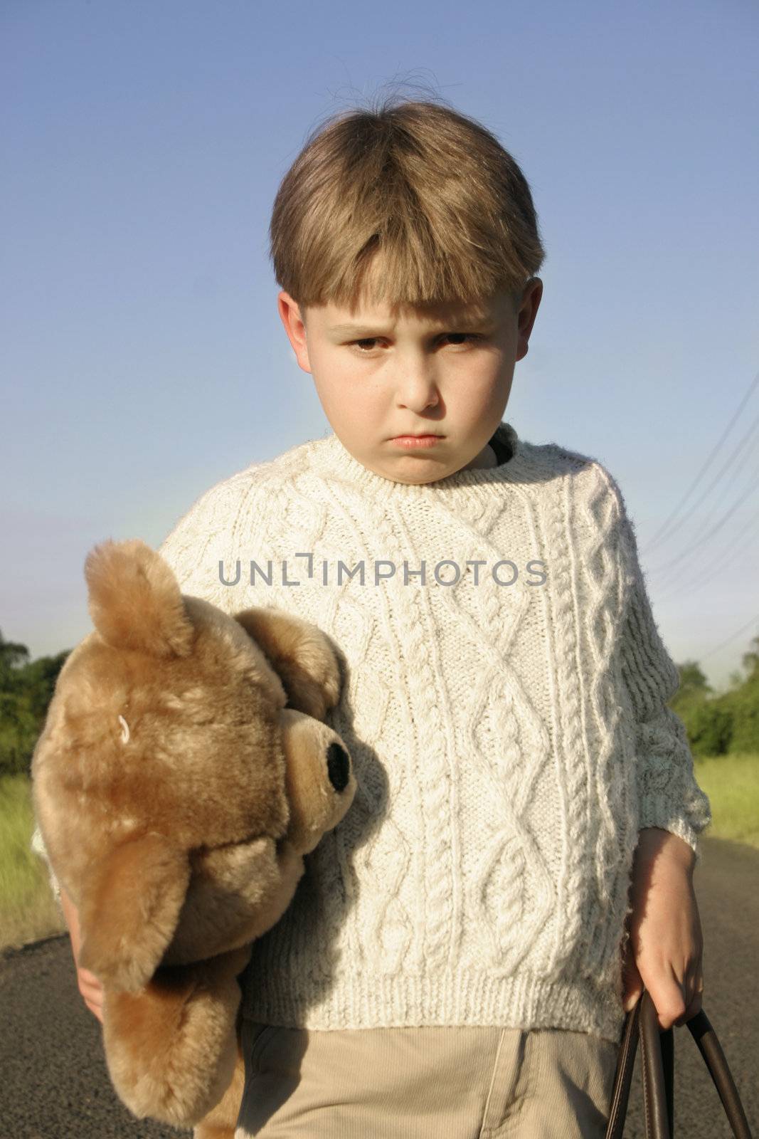 Boy leaves home holding his favourite teddy bear