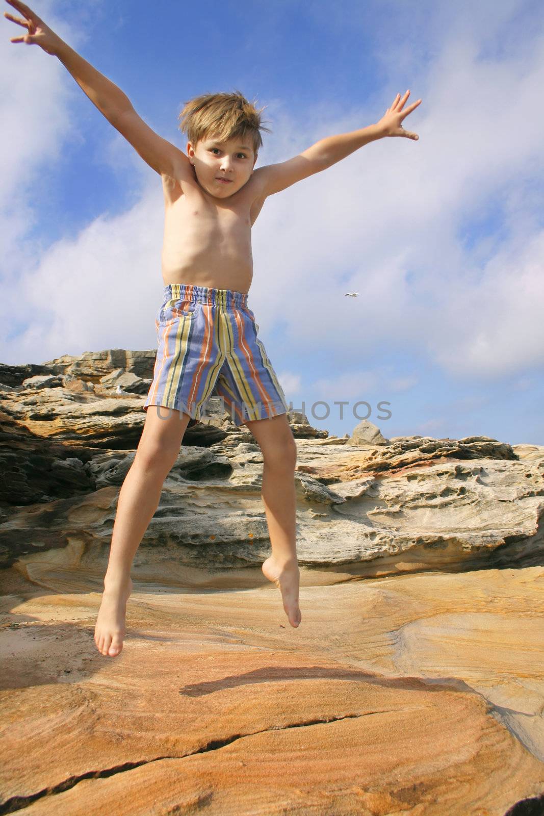 Enthusiastic child burns off energy star jumps. 
