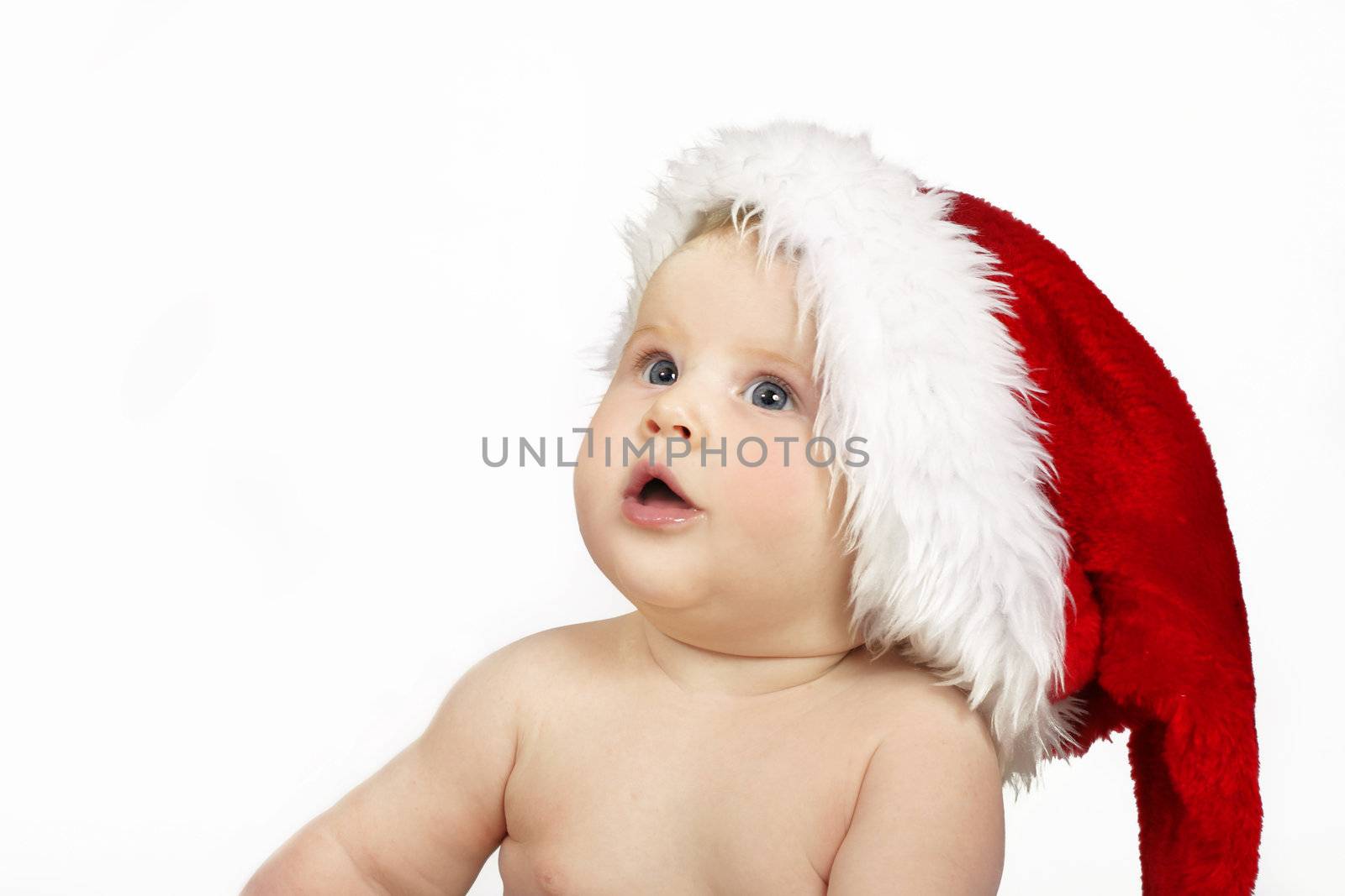 Beautiful infant with blue eyes and a stanta hat.  she is looking skyward - space for copy 
