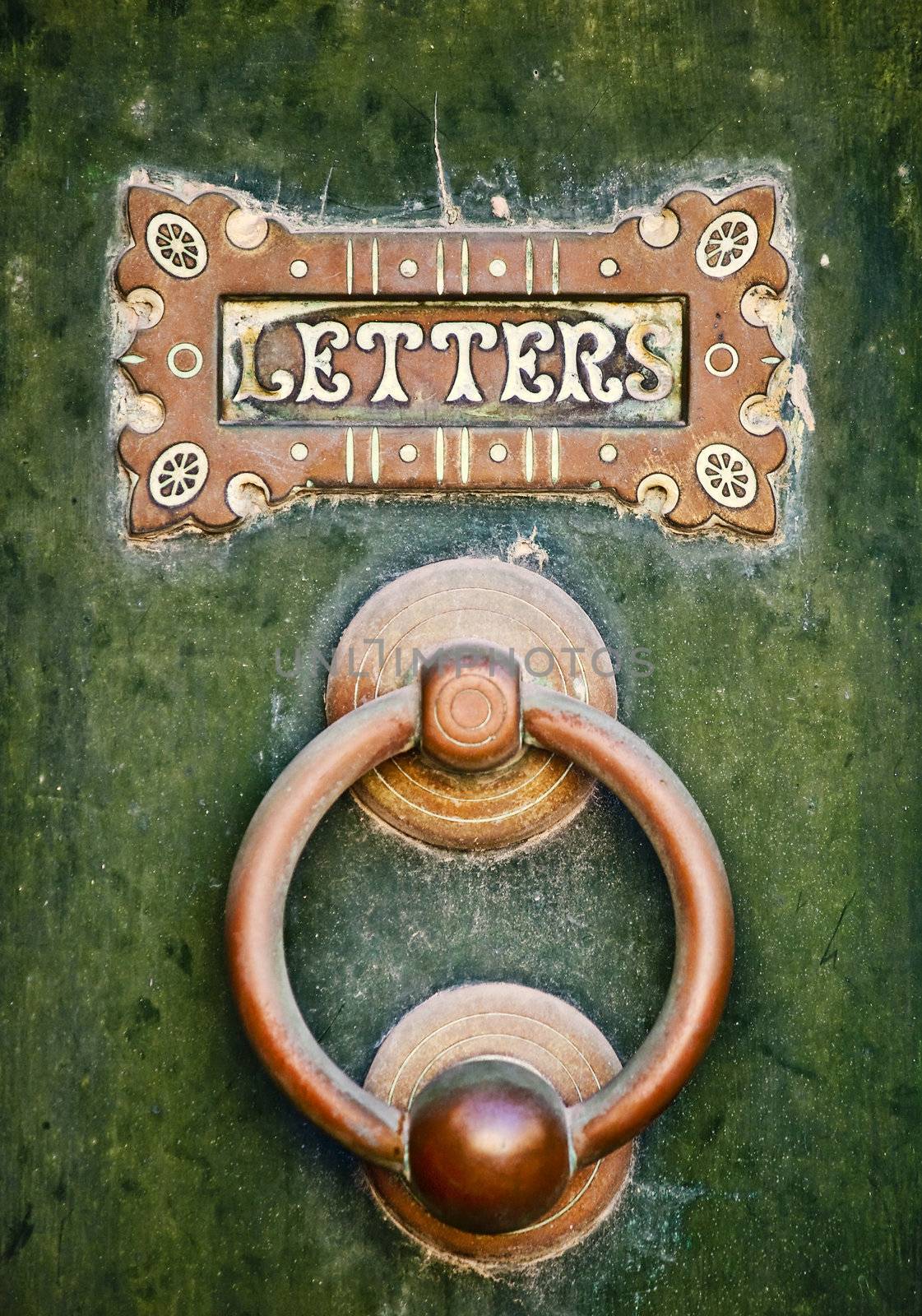An old letterbox and doorknocker on a green door in Mdina in Malta