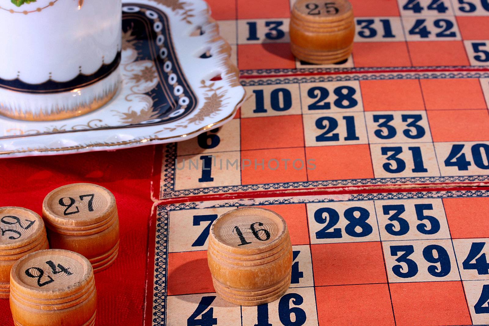 Lotto game on a table with a red cloth, a coffee cup.