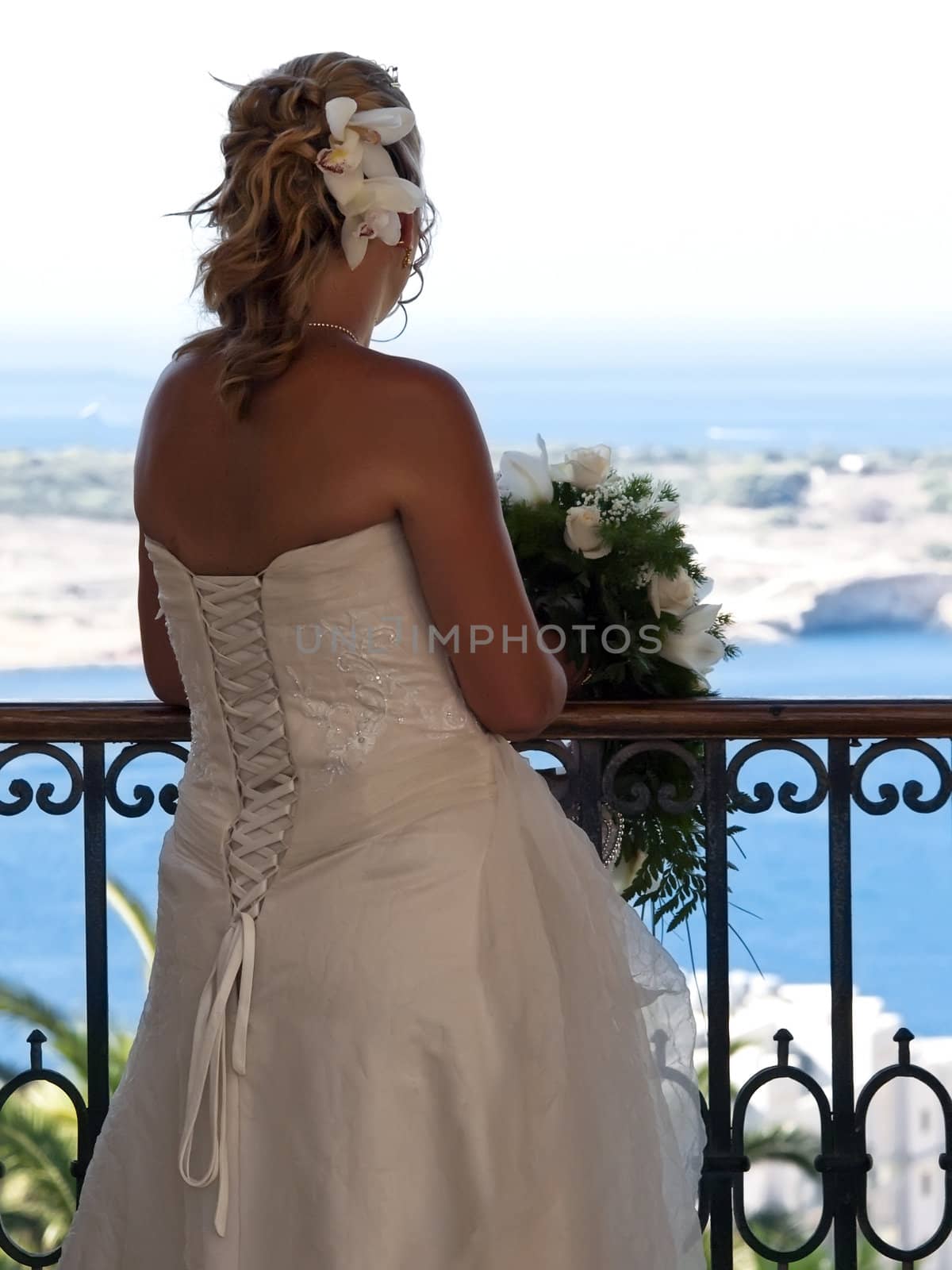 A bride in a balcony looking at the scenery in Malta