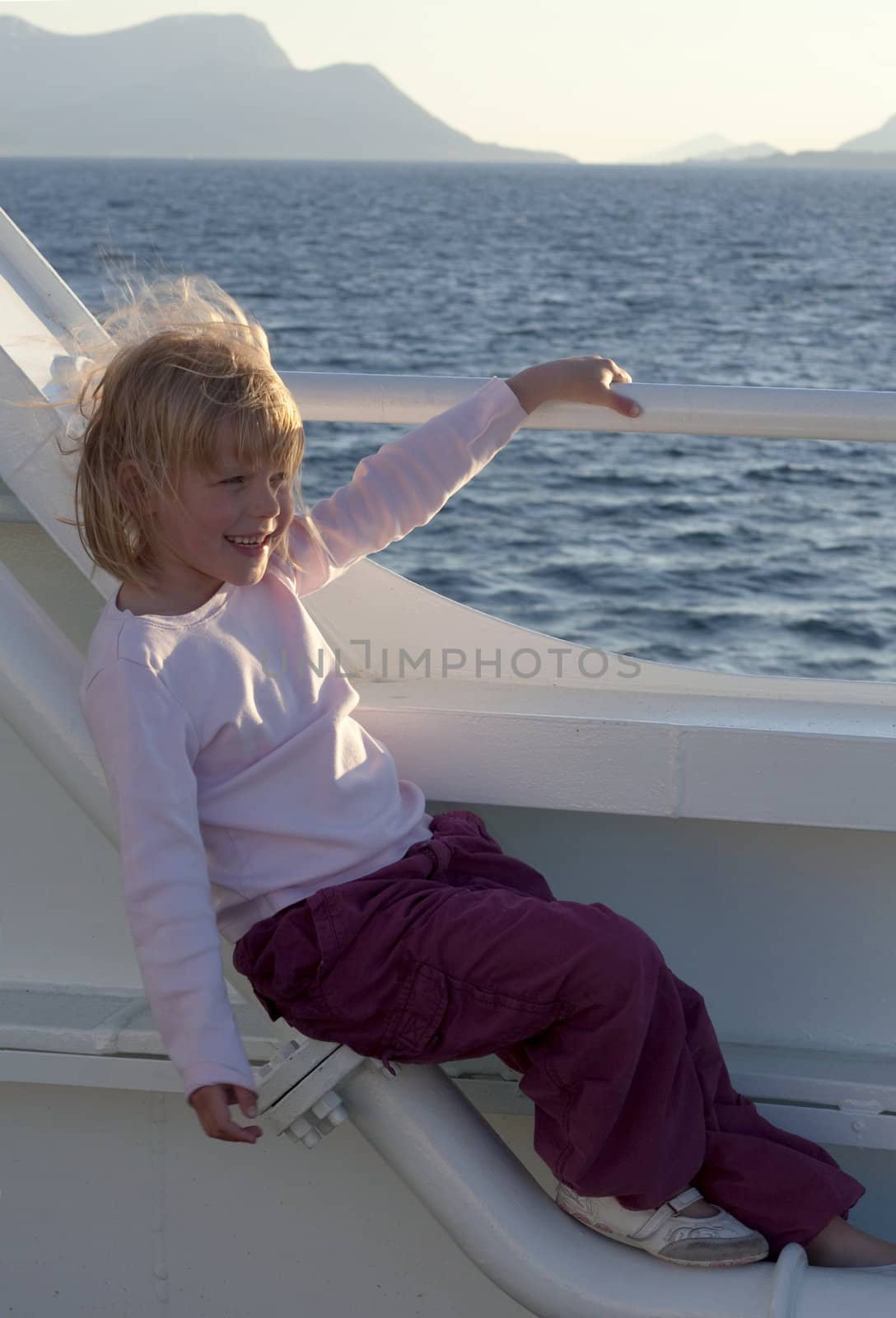 Girl on ferry boat, enjoying the view with wind in her hair