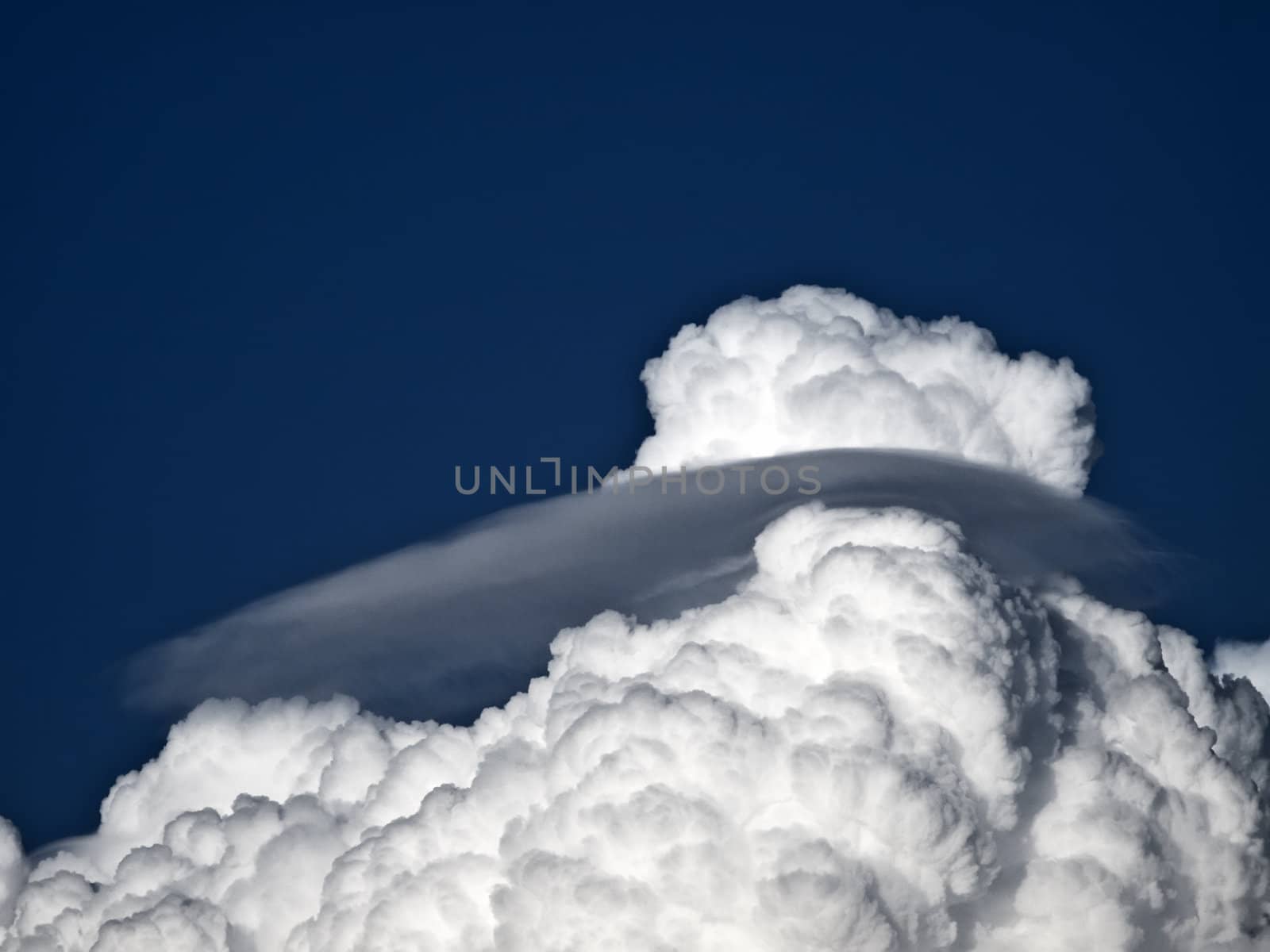 Towering detailed cumulus cloud with lenticular formations