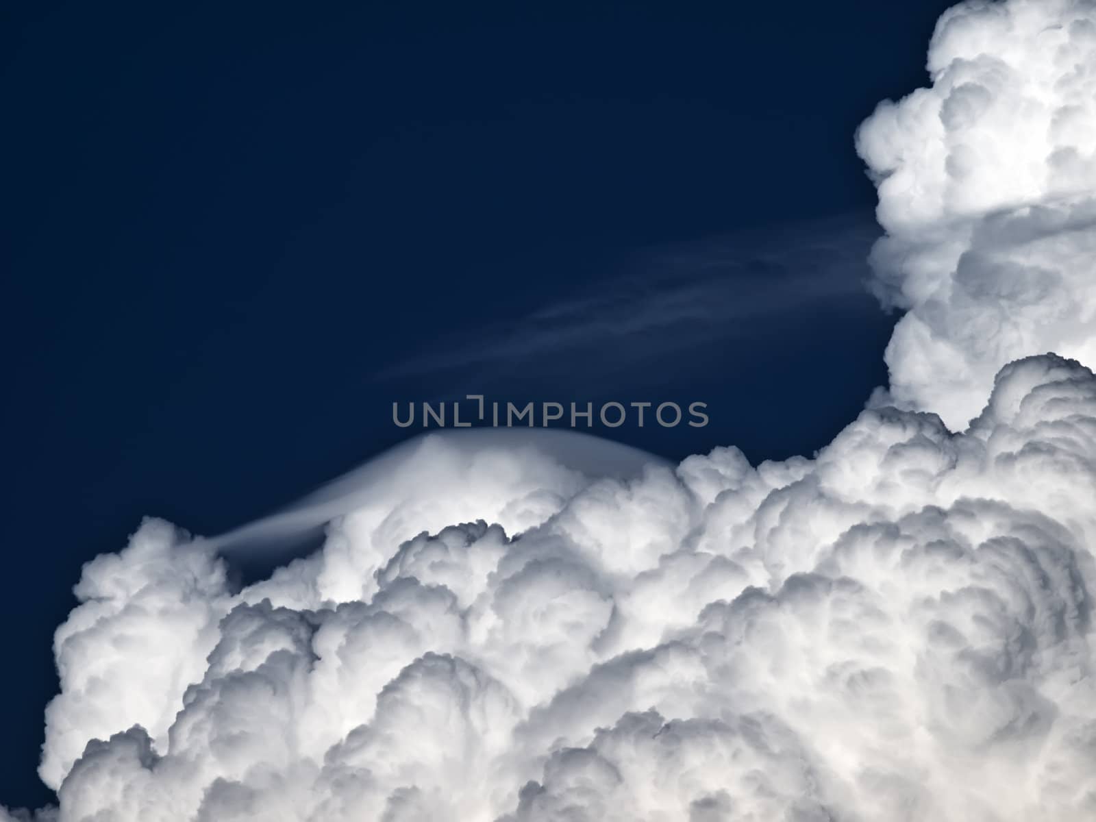 Towering detailed cumulus cloud with lenticular formations