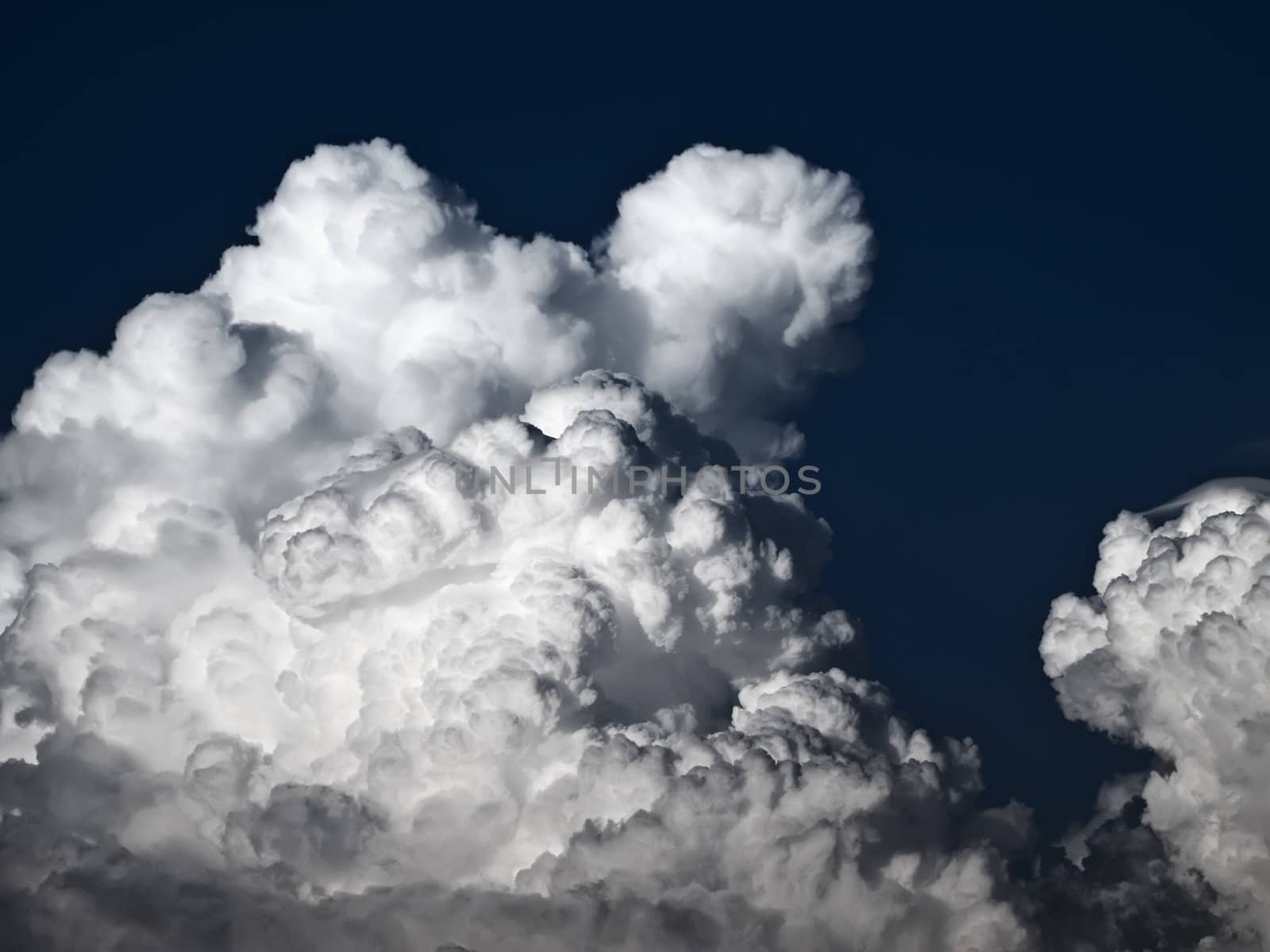 Towering detailed cumulus cloud with lenticular formations