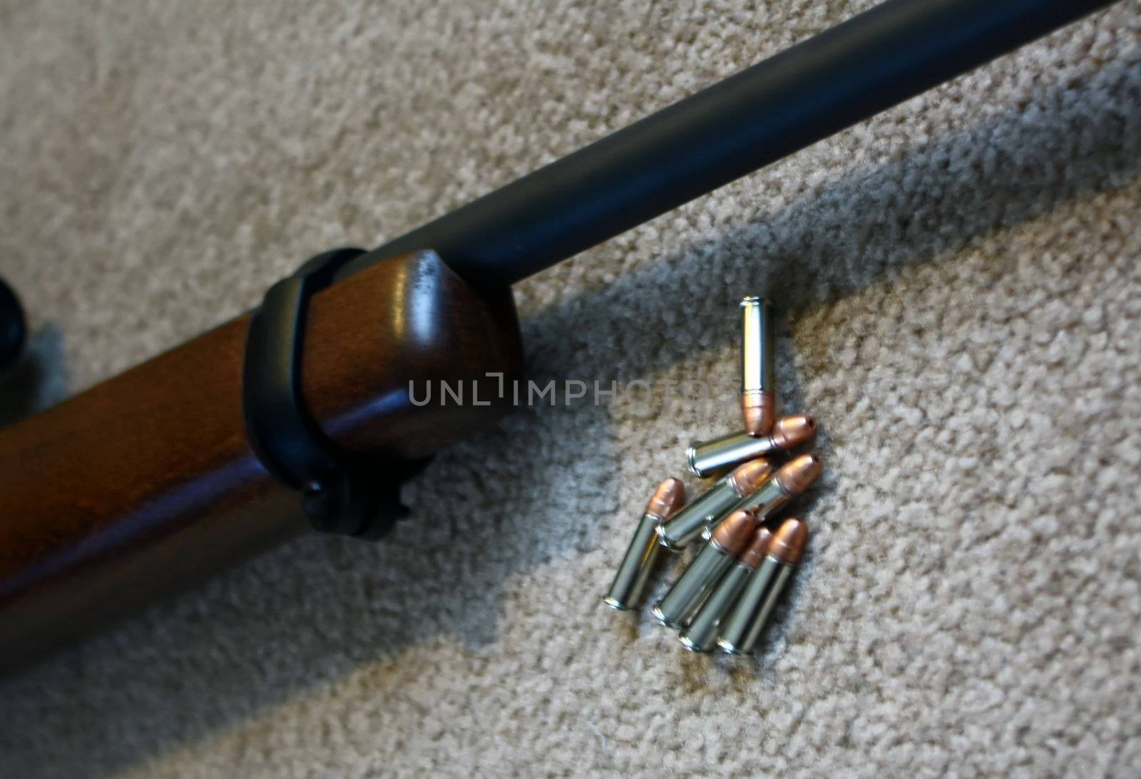 a small pile of bullets next to a rifle