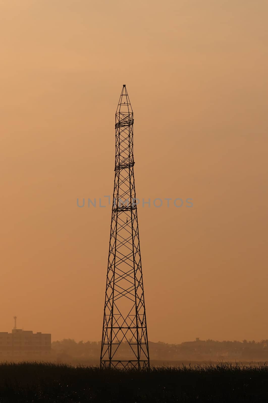 An telecommunication tower during the early morning mist and light