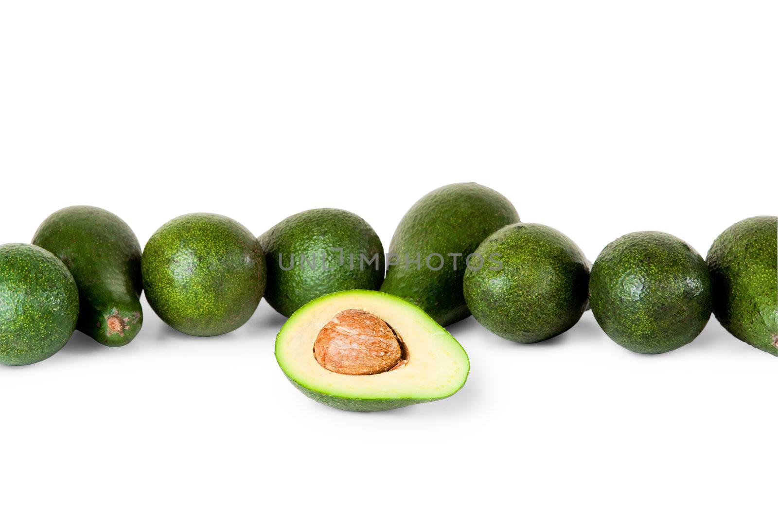 One avocado in front of several more on white background