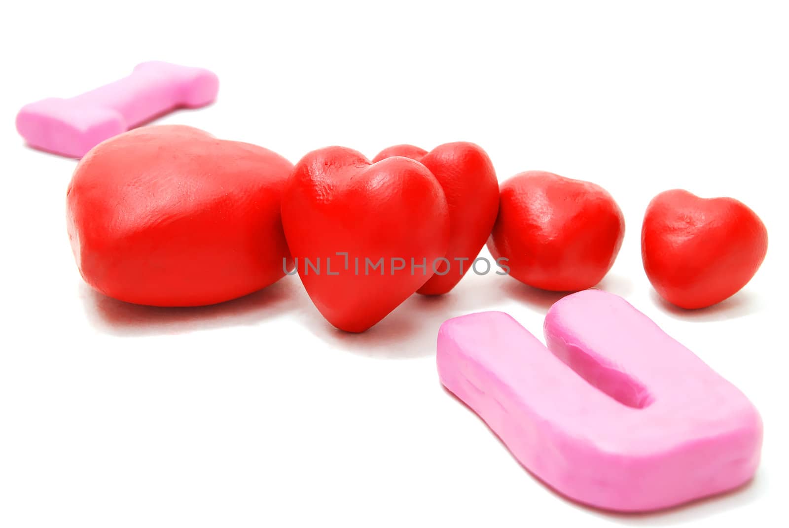 Random Valentine's I Love You Text with Heap of Hearts Made of Red and Pink Plasticine Isolated on White Background