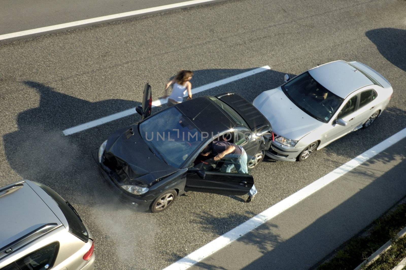 A small shunt on the freeway (motorway, autoroute, autobahn) a few seconds after it happened. Steam can be seen coming from under the bonnet of the black car. Motion blur on the passenger fleeing in panic.