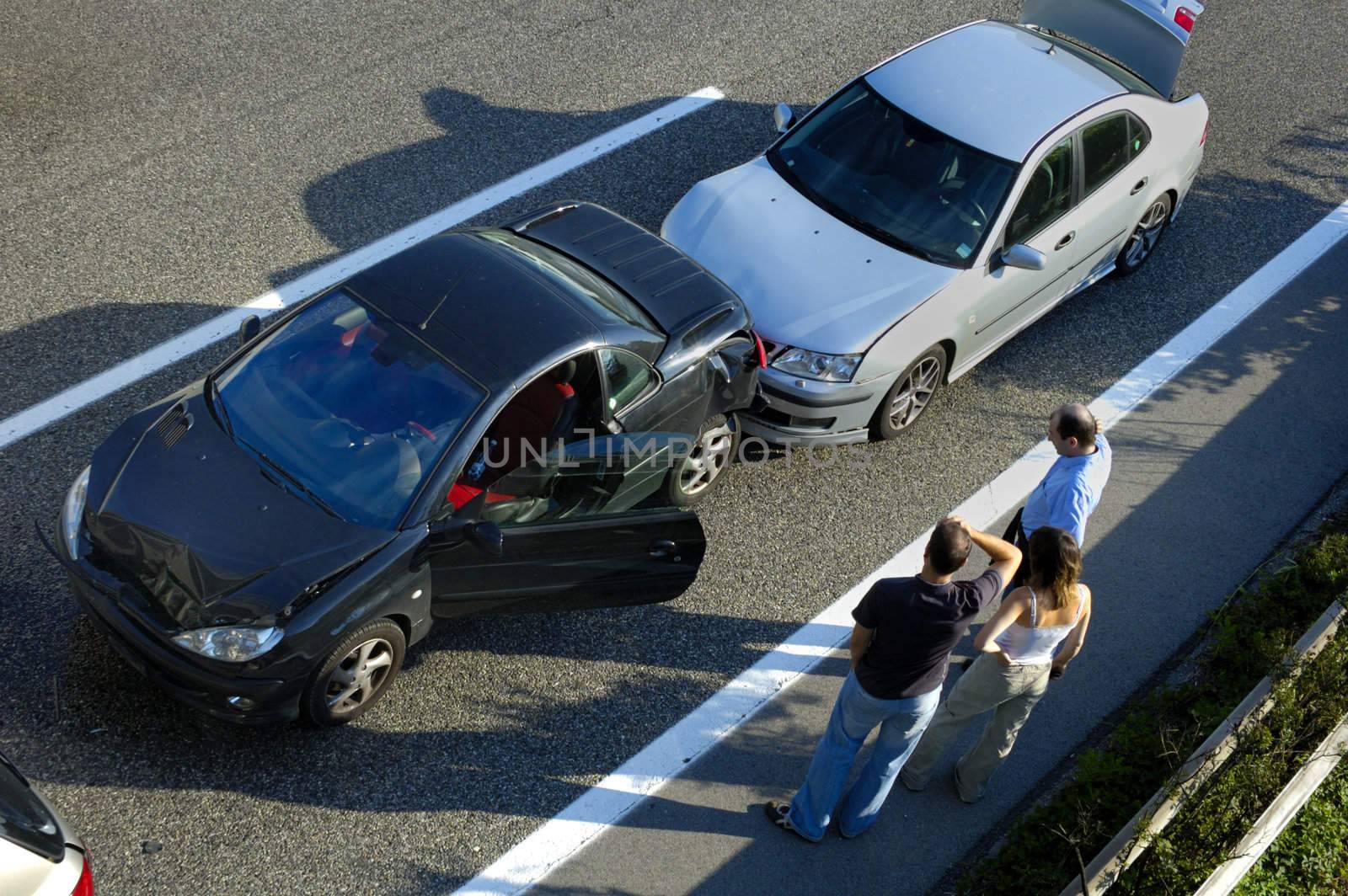 Three people stand by the roadside, discussing what has happened after a small shunt on the freeway (motorway, autoroute, autobahn).