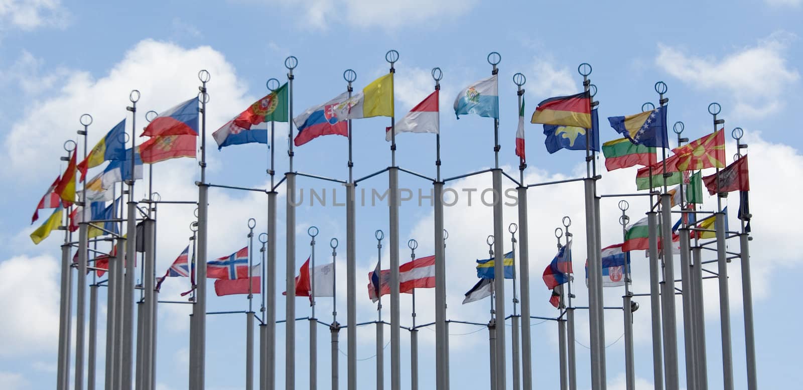 flags of different countries on cloudy blue sky background
