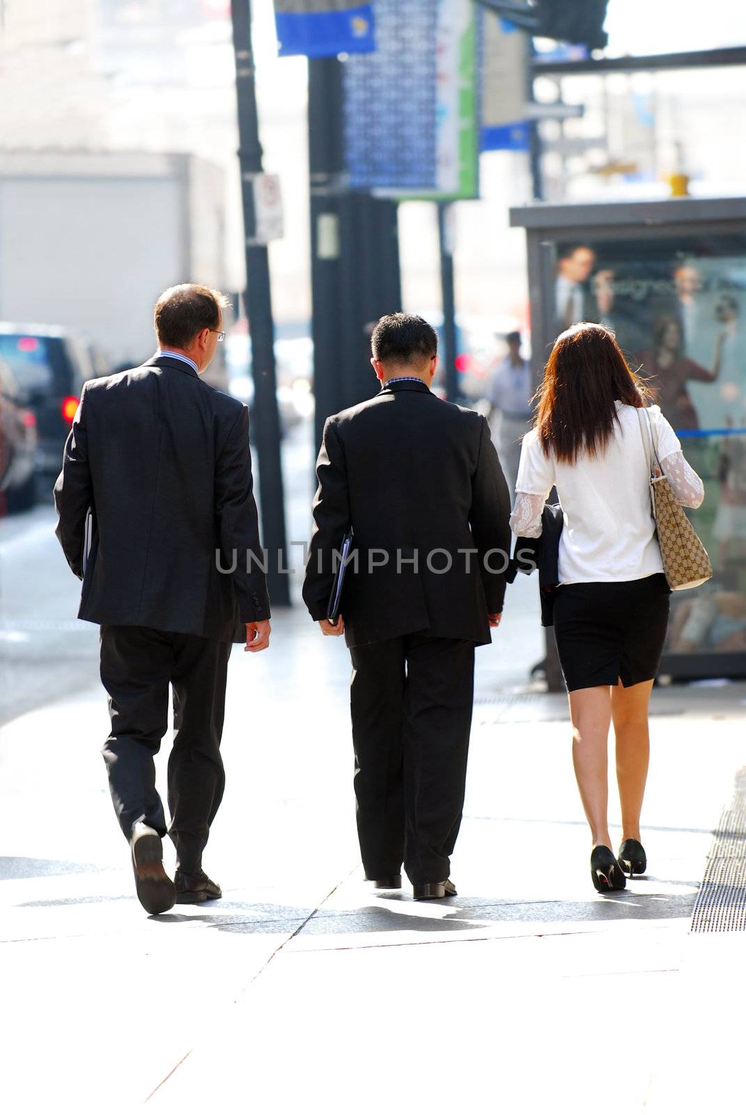 Business team walking on a sidewalk in busy city center