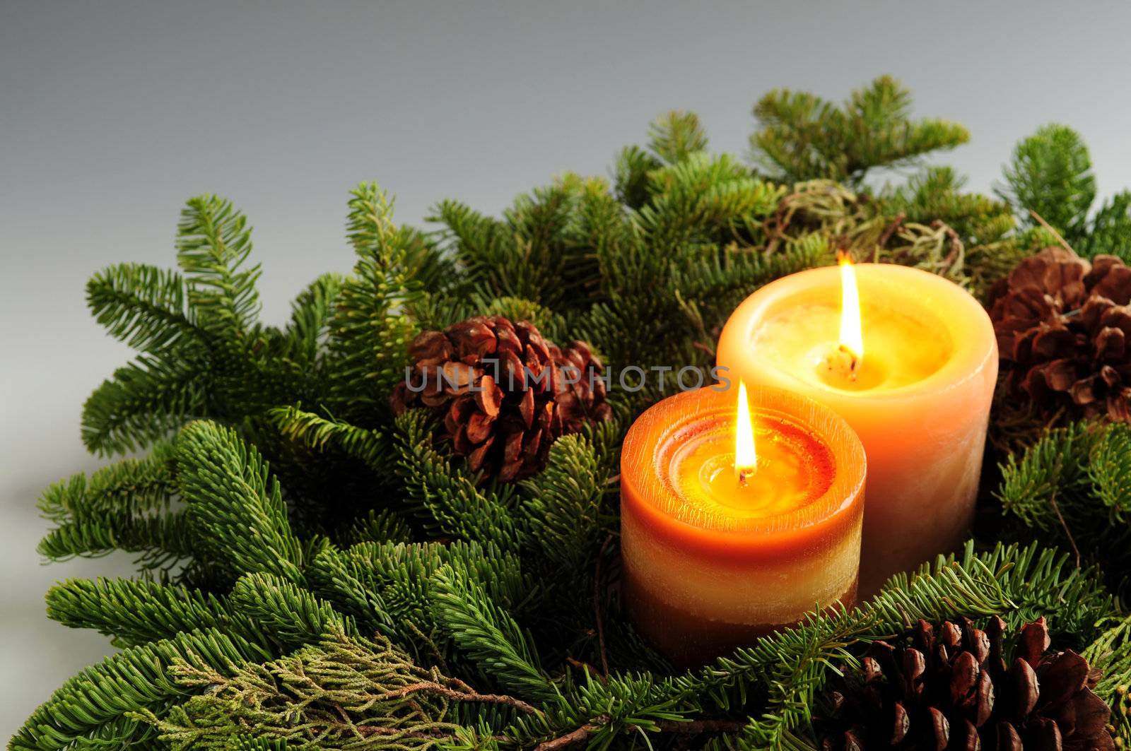 Christmas arrangement of burning candles and green spruce branches