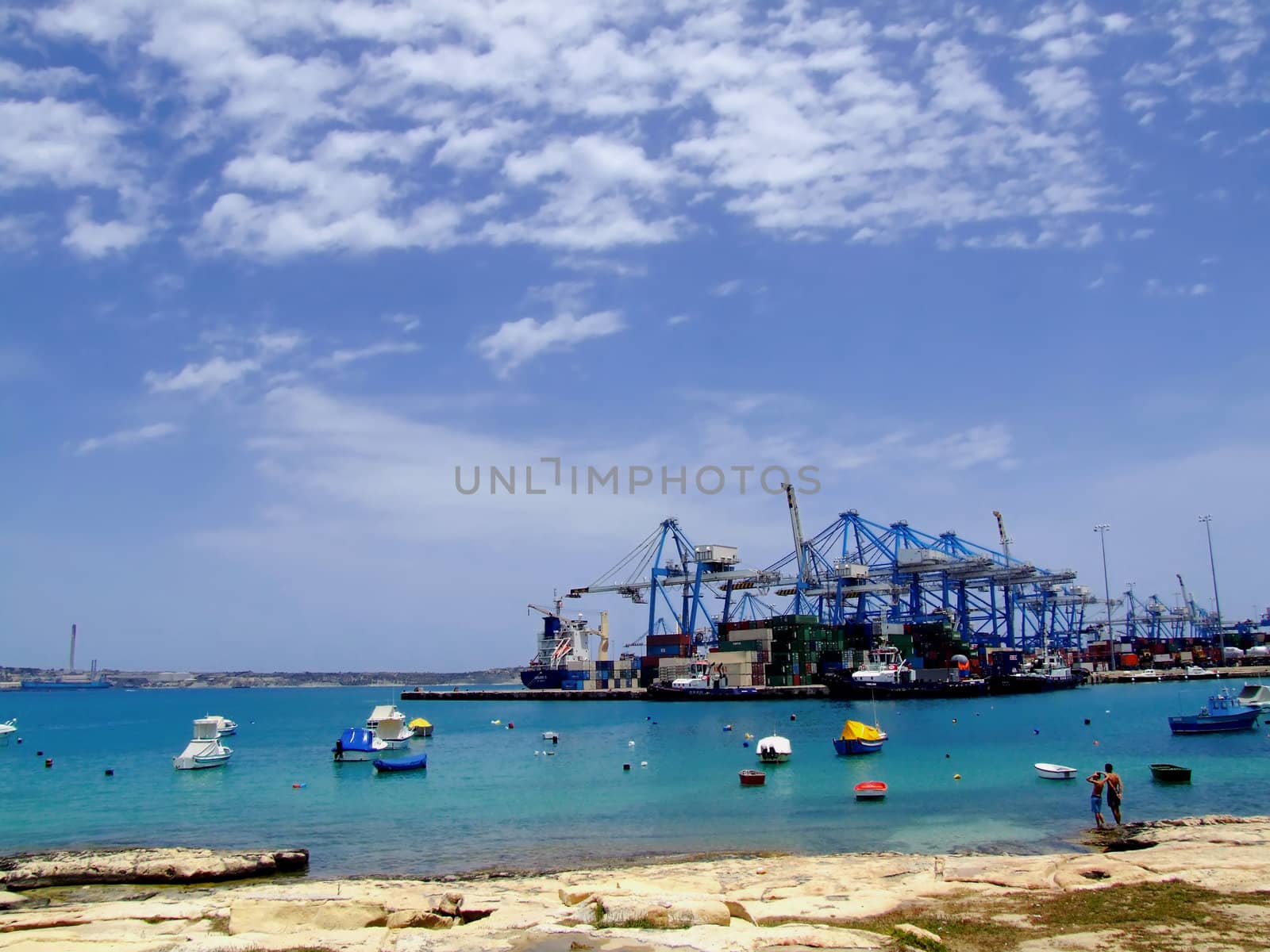 Detail of crane over stacked containers in freighting port in the Med