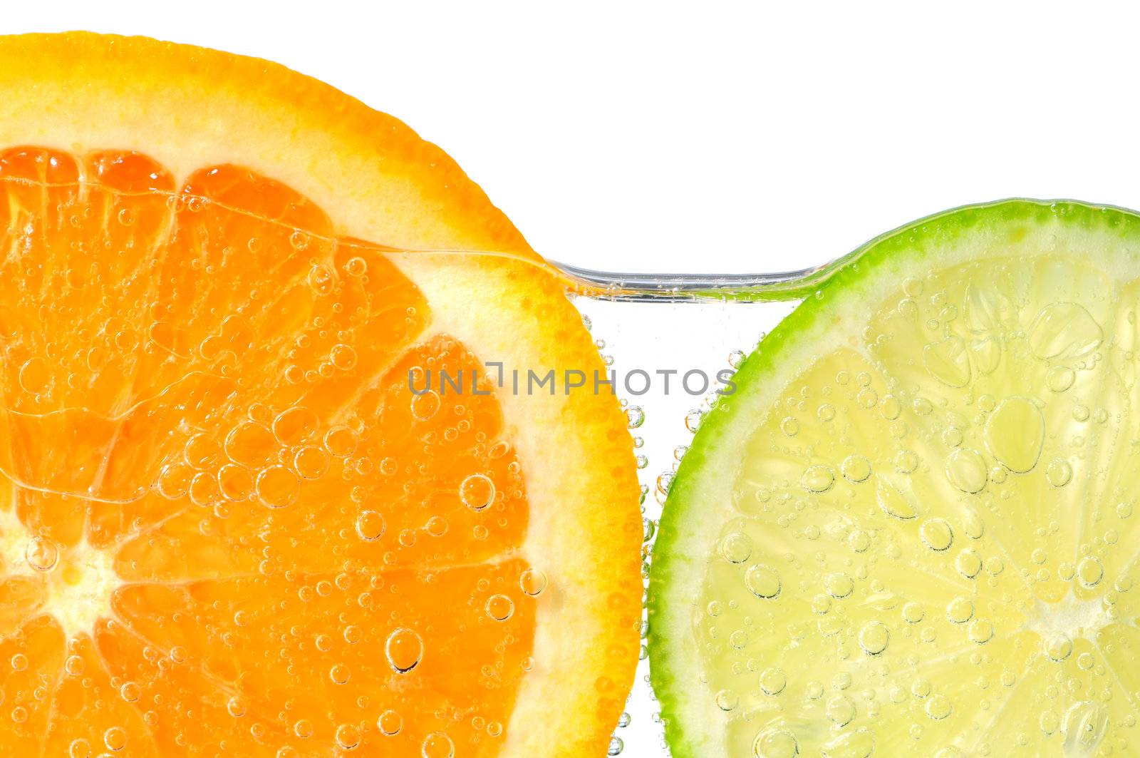 Orange and lime slices in water by elenathewise