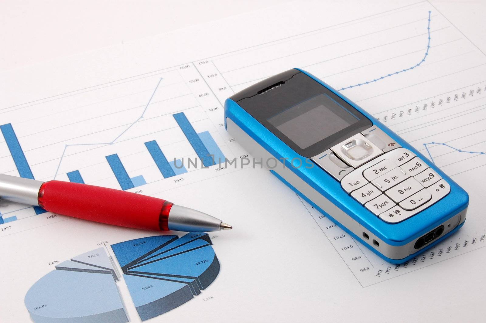 blue cell phone over business chart showing success
