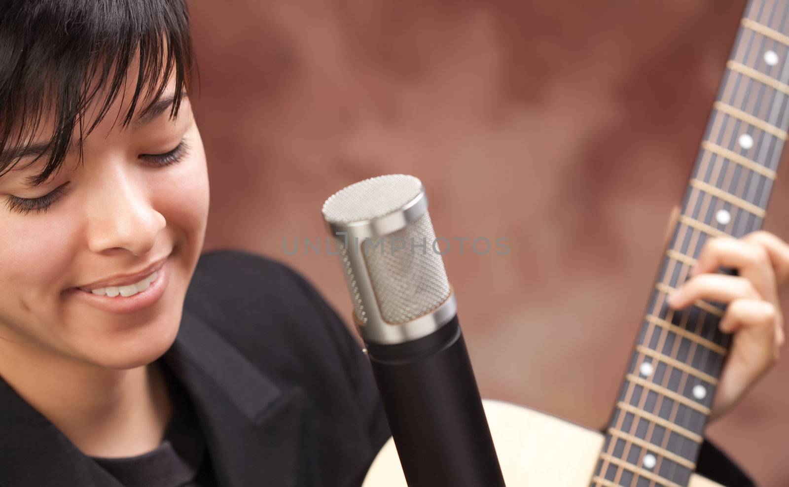 Attractive Ethnic Girl Enjoys Playing Her Guitar.