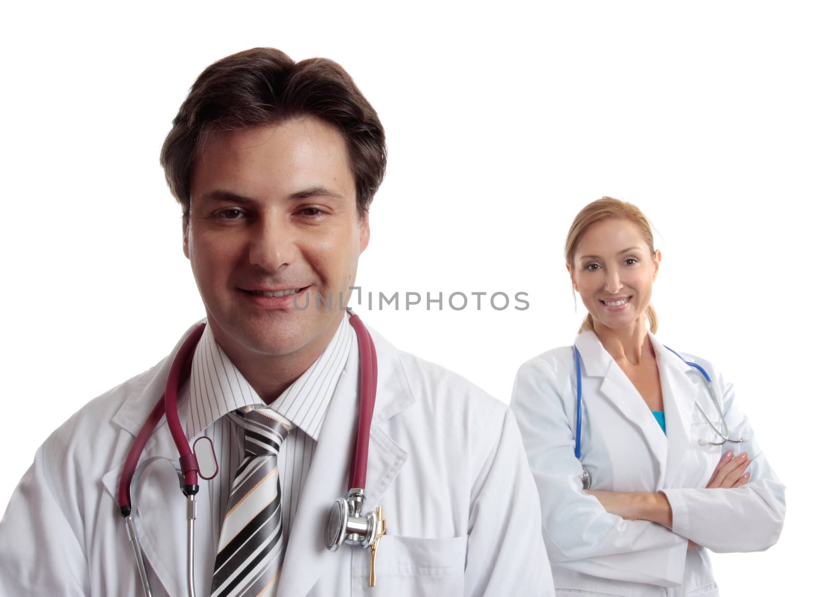 Two confident healthcare workers dressed in uniform  smile casually.  Focus to male doctor.