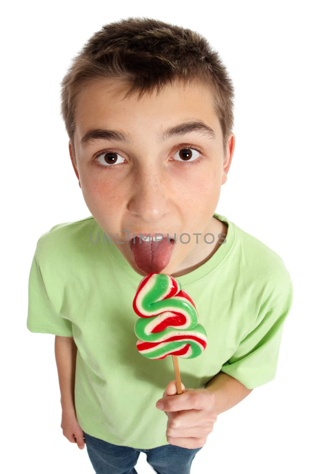 A boy eating a large lollipop on a stick.  Above perspective