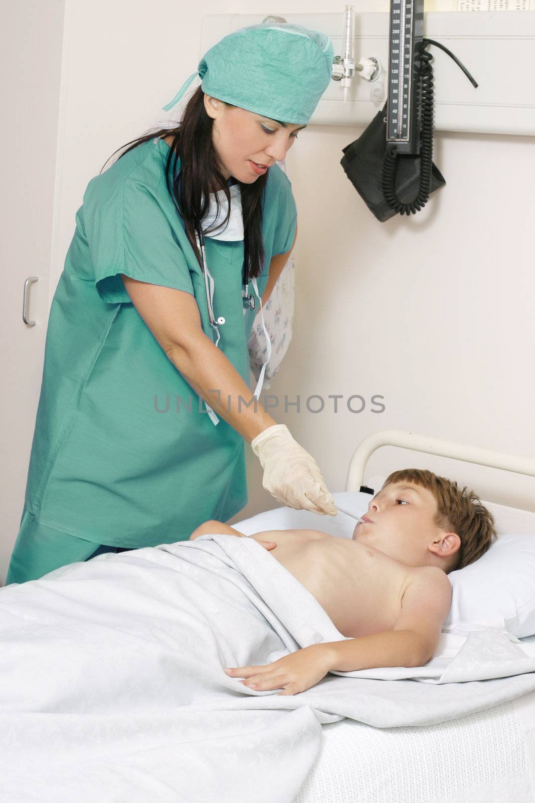 Nurse in scrubs takes a child's temperature
